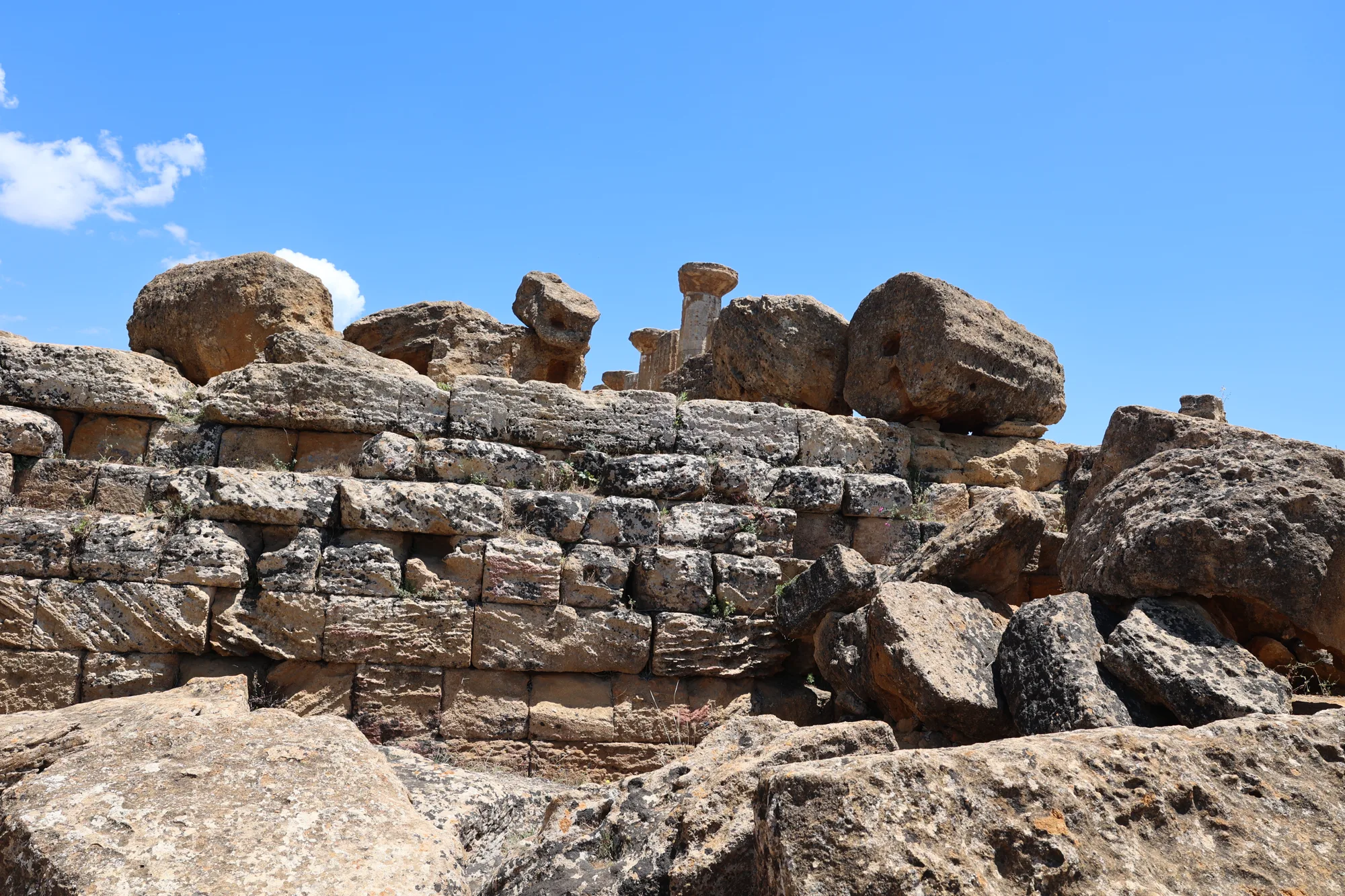 Les blocs au sol révèlent l’épaisseur et la texture des constructions antiques.