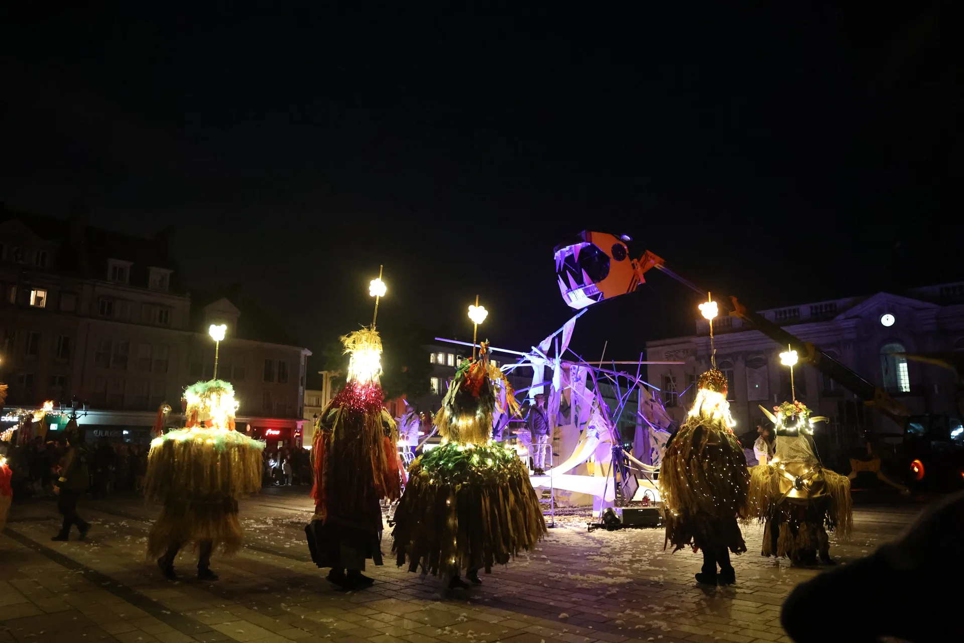 Les personnages et la cabane éclairés pendant La Cabane à Plume(s) à Beauvais.