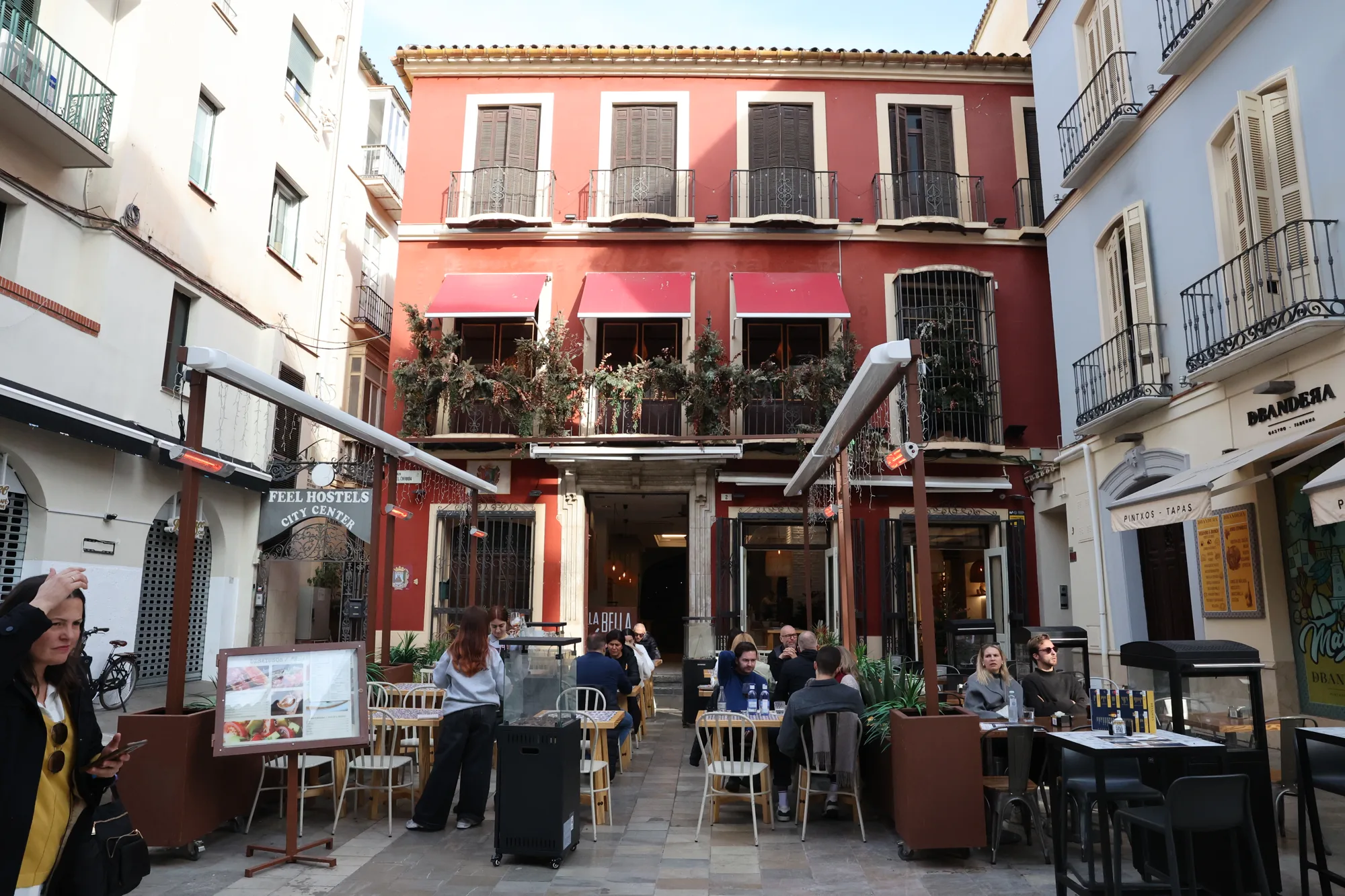 Une petite place, ses terrasses et sa façade rouge.