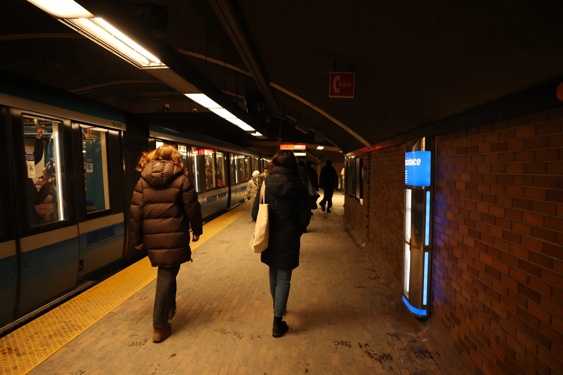 Quai du métro, voyageurs et éclairages au-dessus des voies