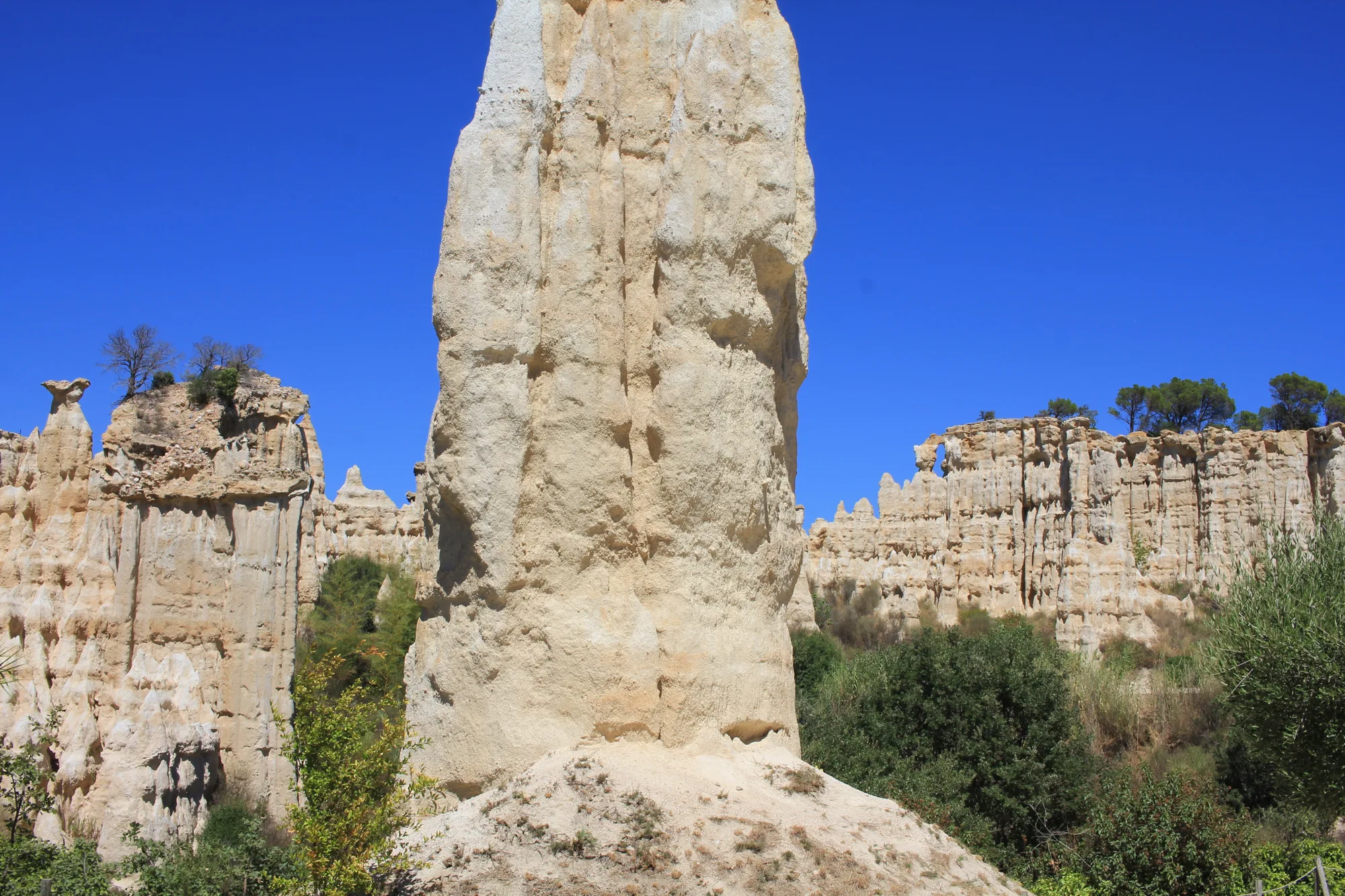 Une colonne isolée devant les reliefs.