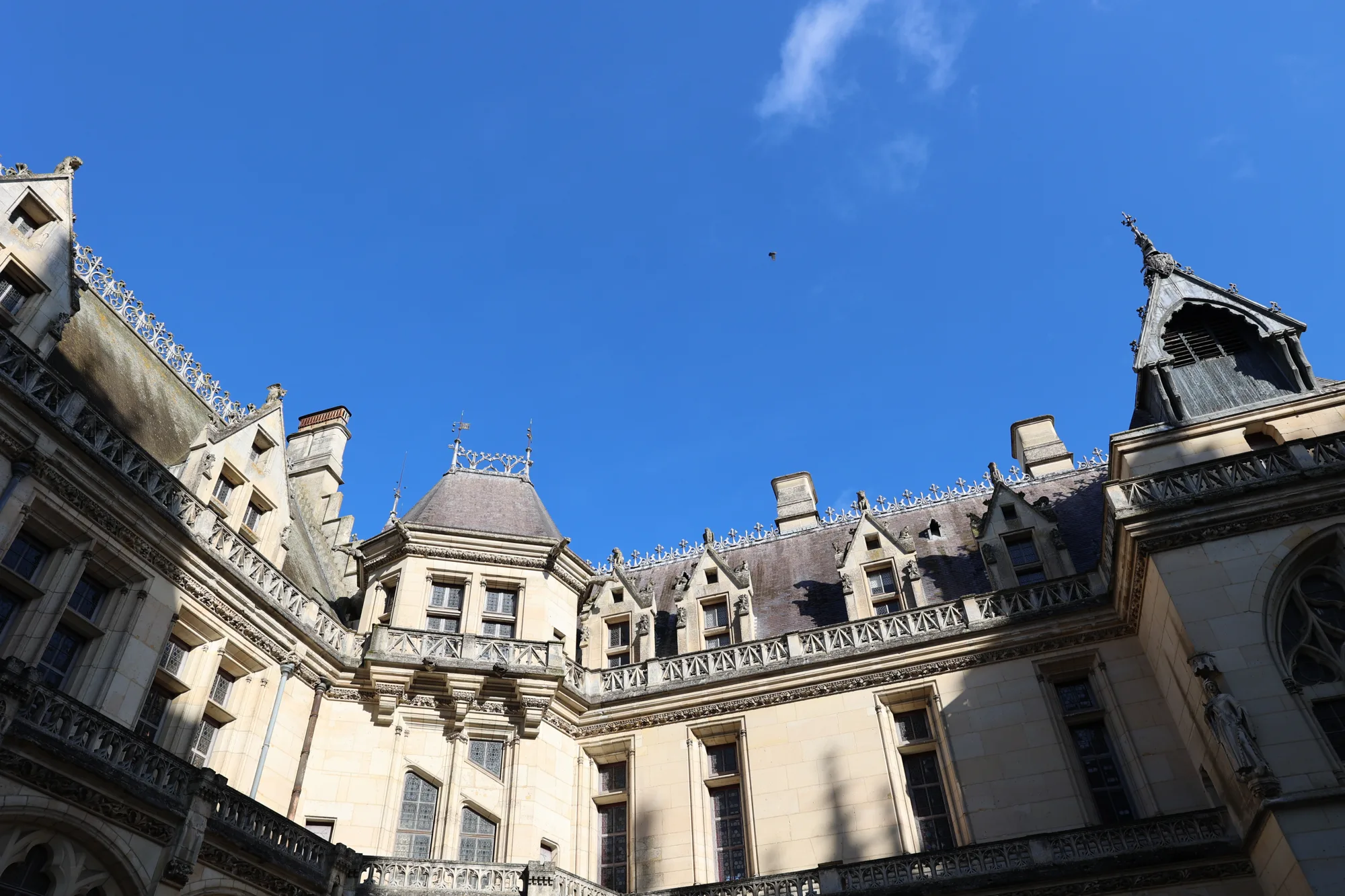 Dans la cour, les toitures et les façades découpent le ciel de février.