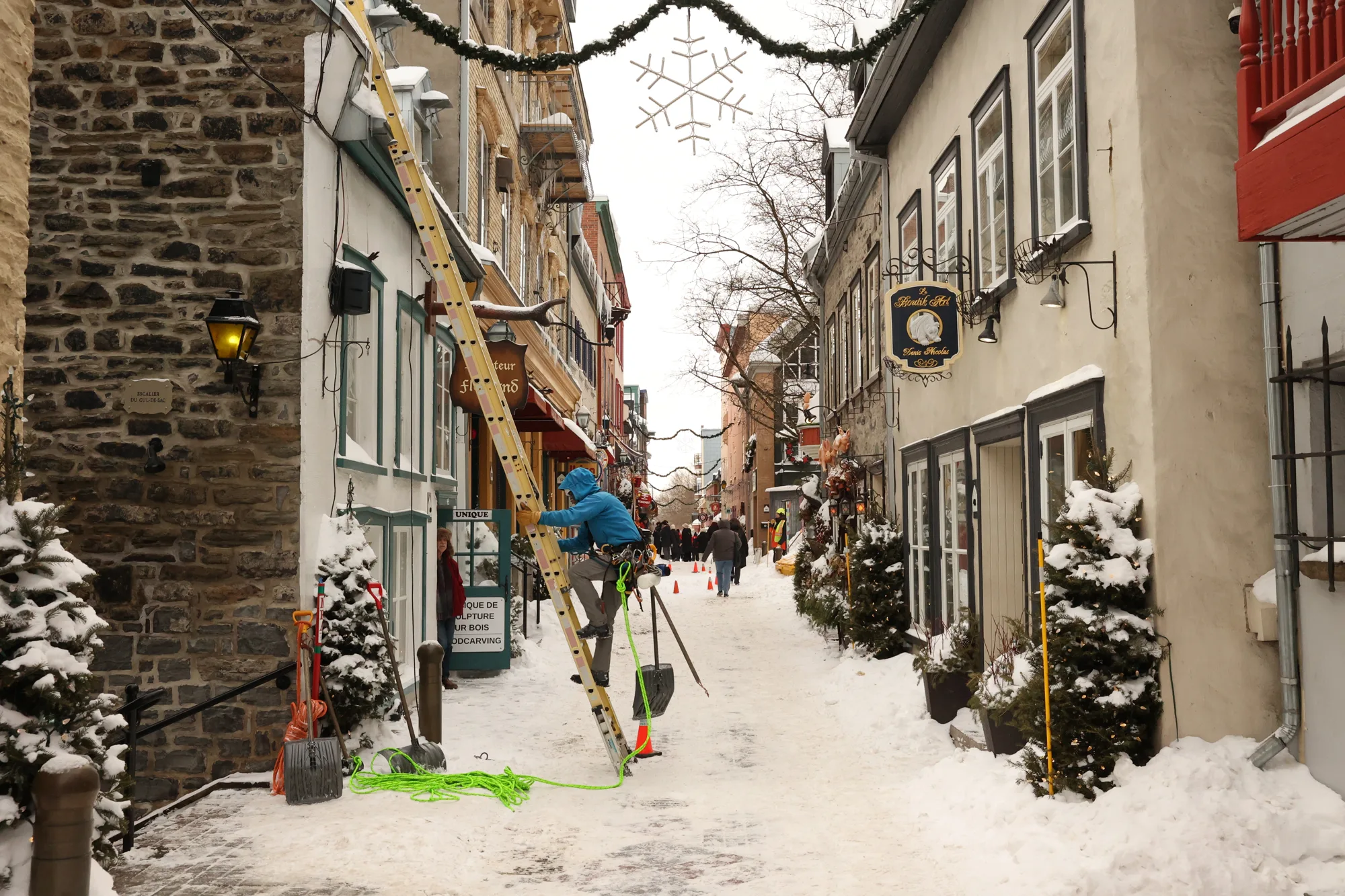 Dans le Petit-Champlain, enseignes et décorations accompagnent la rue enneigée.