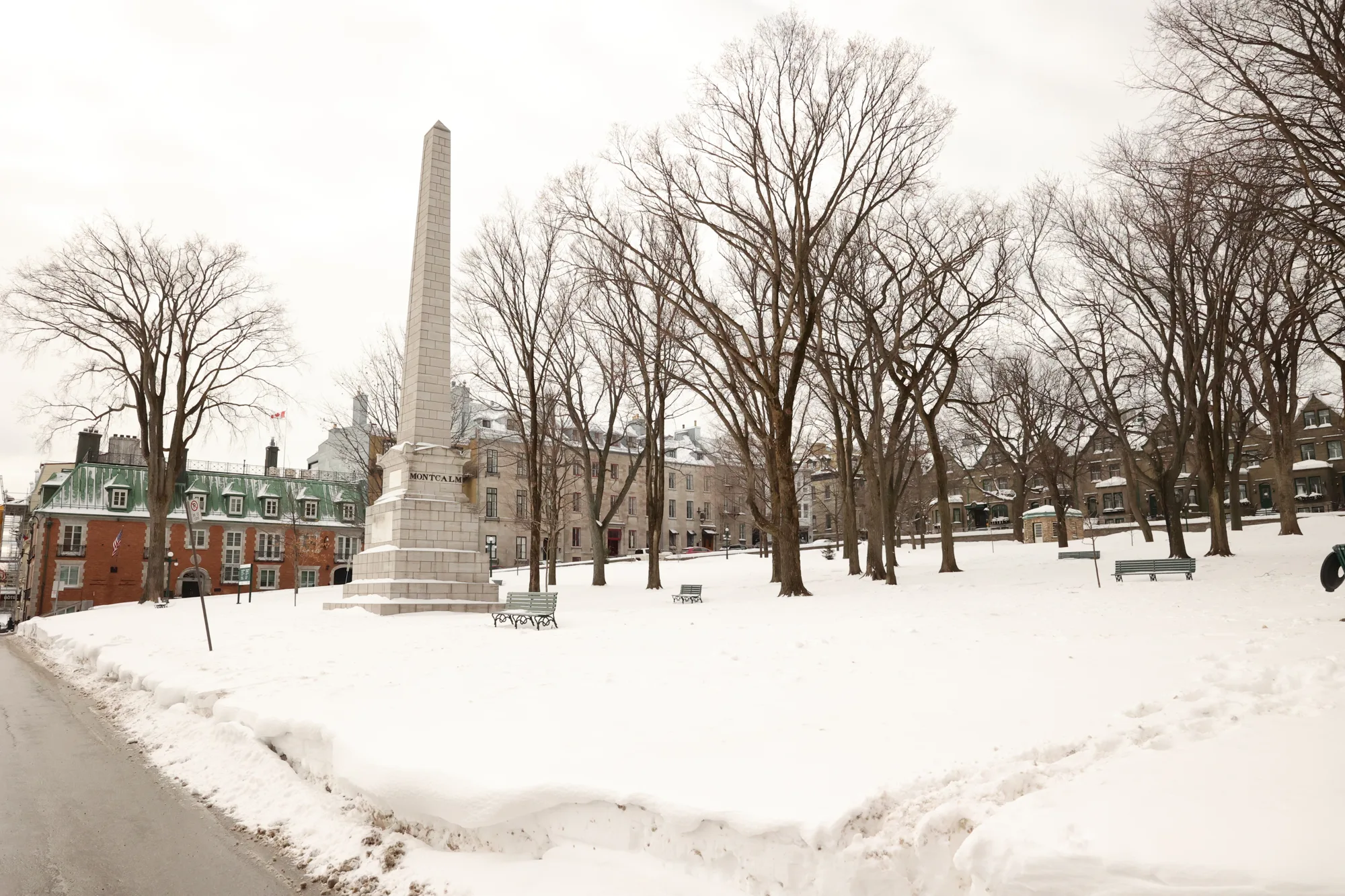Les arbres dénudés et le monument se détachent sur la neige.