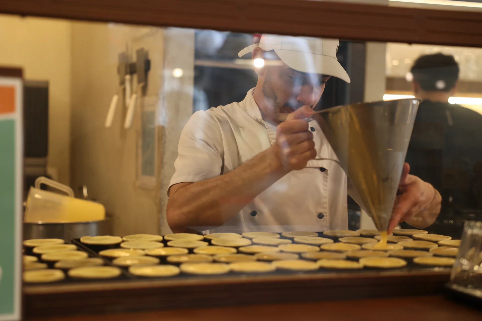 La fabrication des pastéis de nata derrière la vitre d’une boutique à Lisbonne.