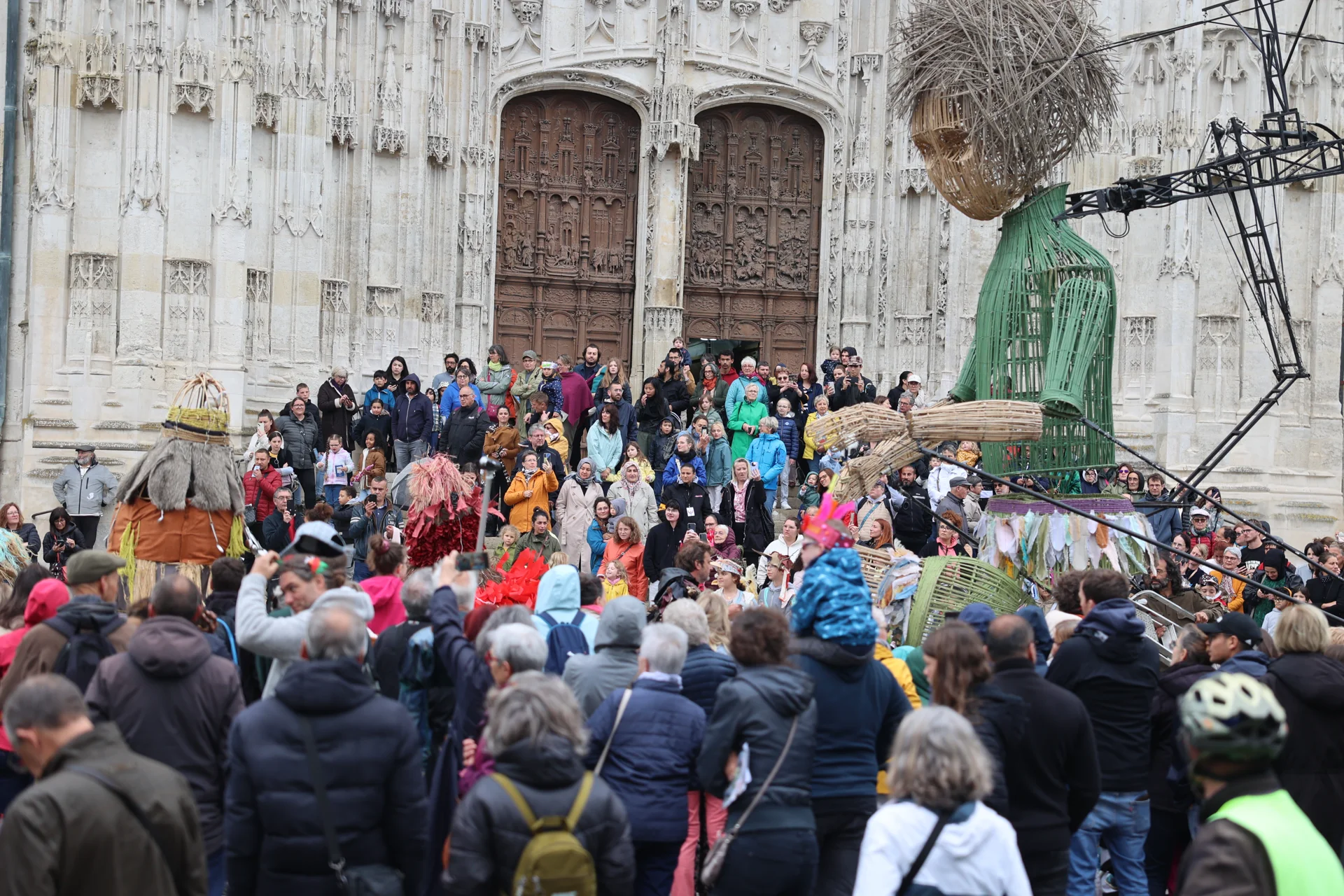 Plume et un groupe aux vêtements colorés devant la cathédrale Saint-Pierre de Beauvais.