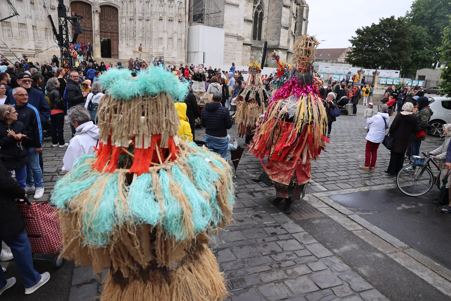 Des costumes aux longues franges colorées devant la cathédrale de Beauvais.