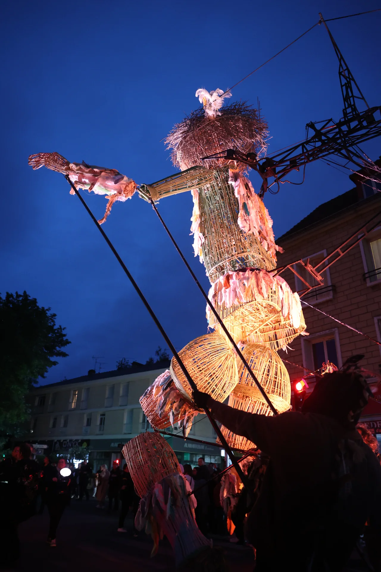 La marionnette géante Plume éclairée dans la nuit de Beauvais.