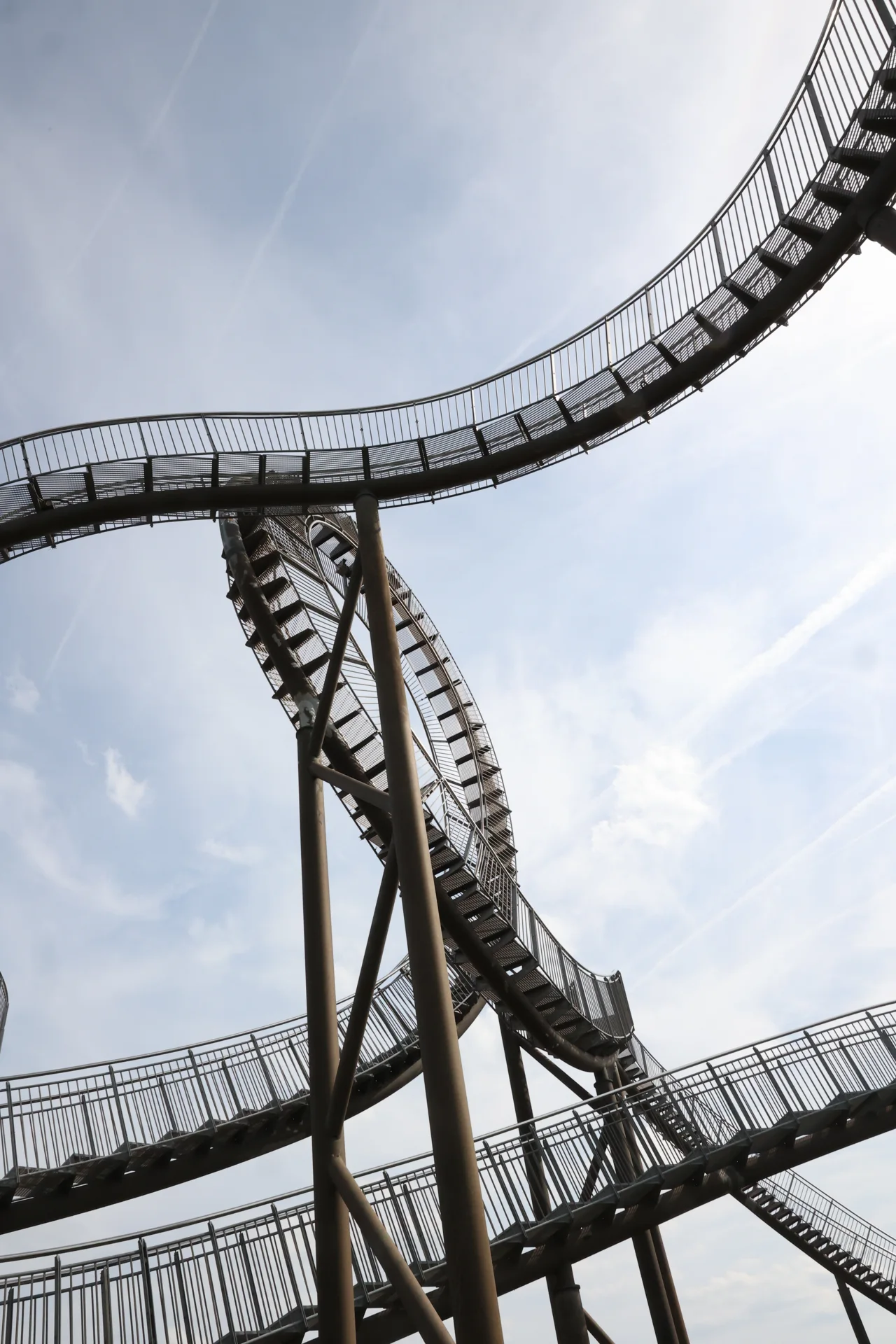 Une courbe de l’escalier métallique de Tiger and Turtle se détache sur le ciel.